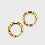 Pair of gold hoop earrings on a light gray background