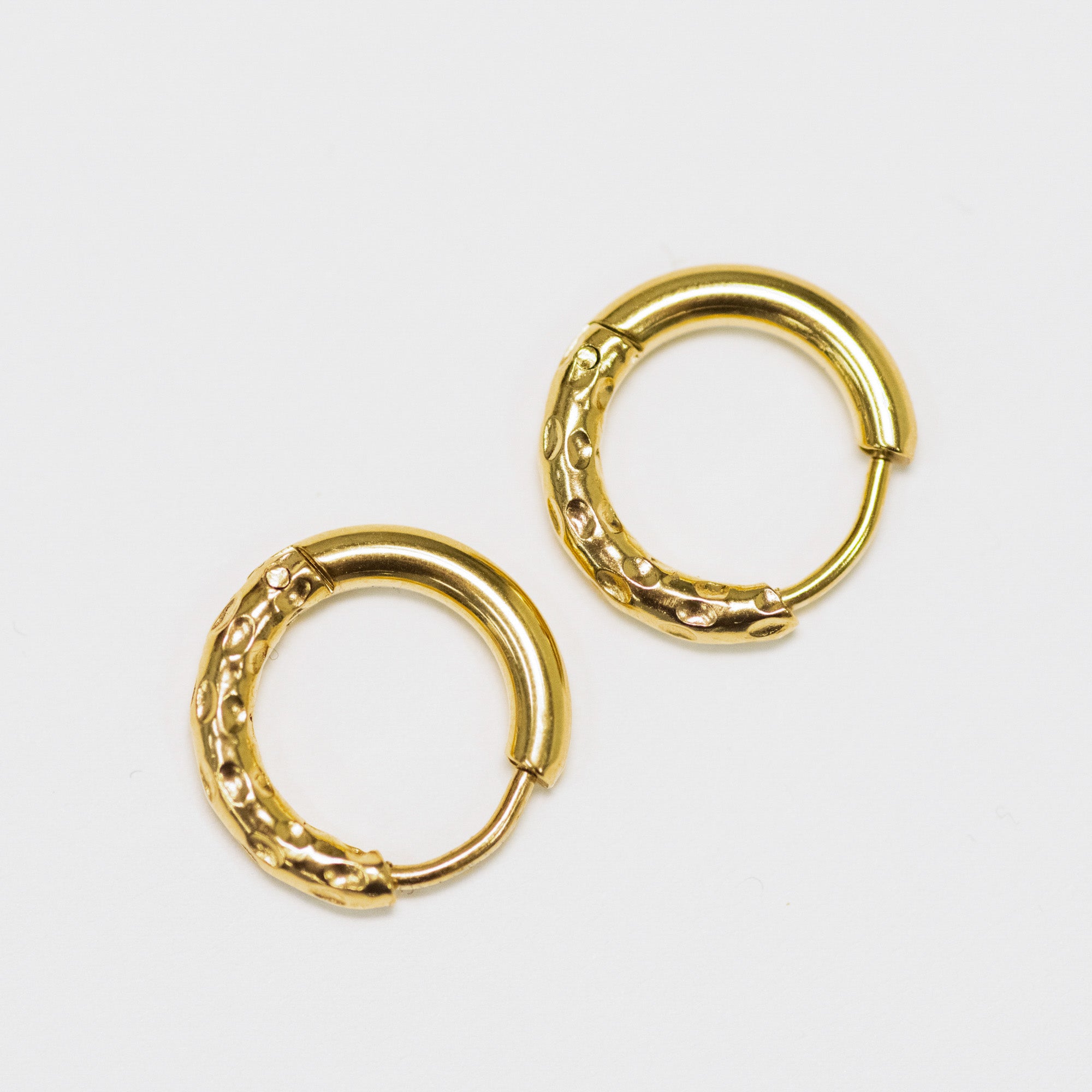 Pair of gold hoop earrings on a light gray background