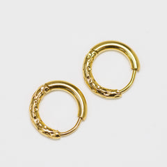 Pair of gold hoop earrings on a light gray background