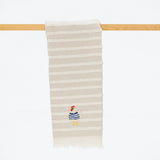 taupe and cream striped turkish cotton towel with fringe and embroidered chicken wearing a blue sweater.