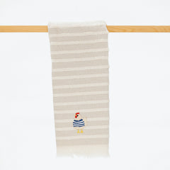 taupe and cream striped turkish cotton towel with fringe and embroidered chicken wearing a blue sweater.