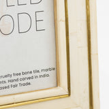 Close-up of a framed text with a gold border on a white background
