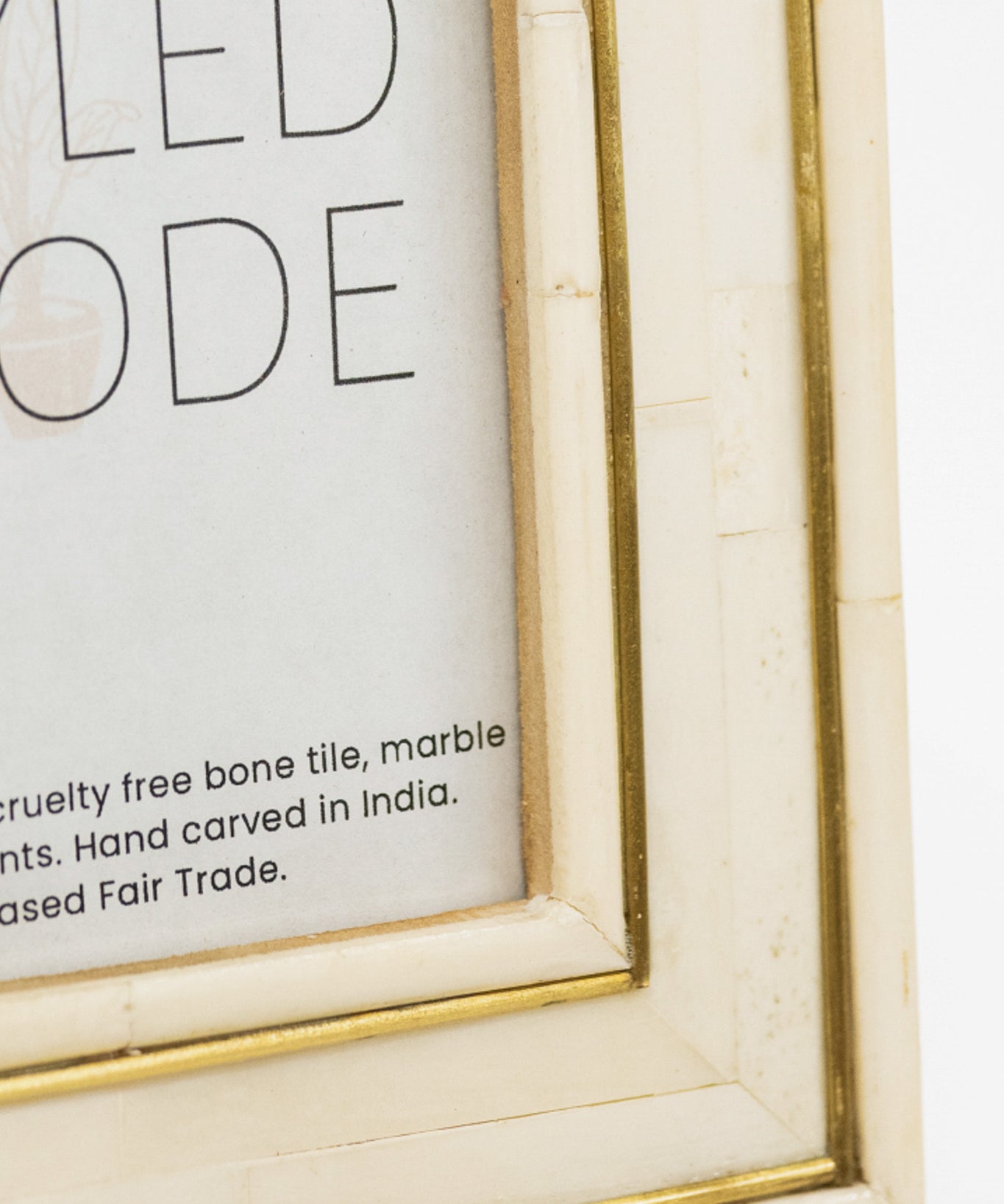 Close-up of a framed text with a gold border on a white background