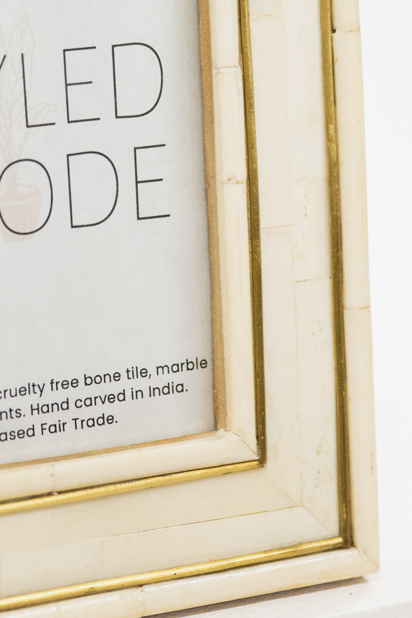 Close-up of a framed text with a gold border on a white background