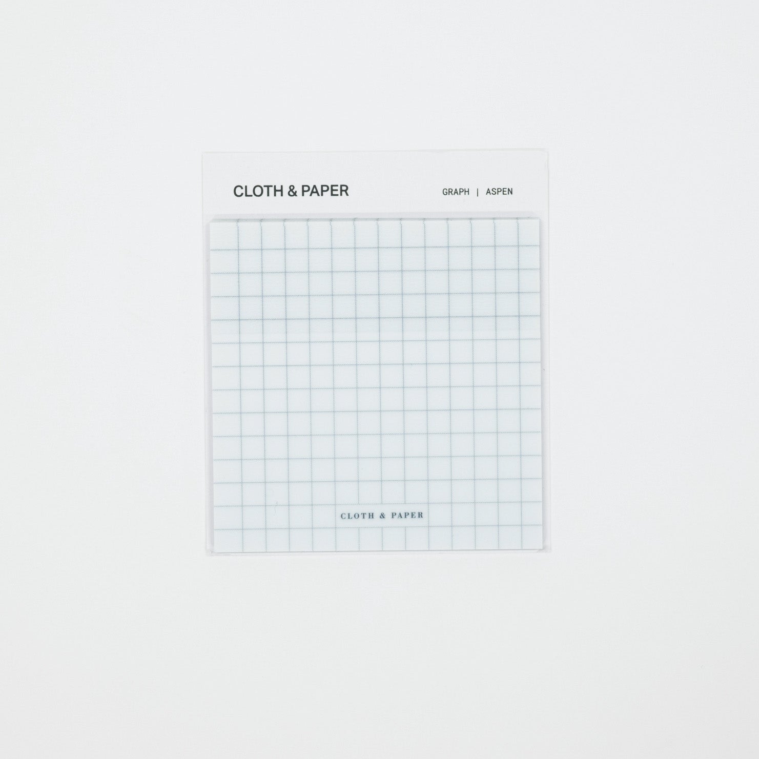 A square white notepad with a light blue grid pattern, labeled 'CLOTH & PAPER' and 'GRAPH | ADPEN', centered on a plain white background.