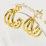Gold hoop earrings on a clear stand against a white background