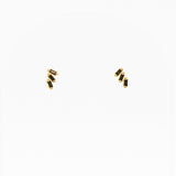 Gold earrings with black stones on a white background