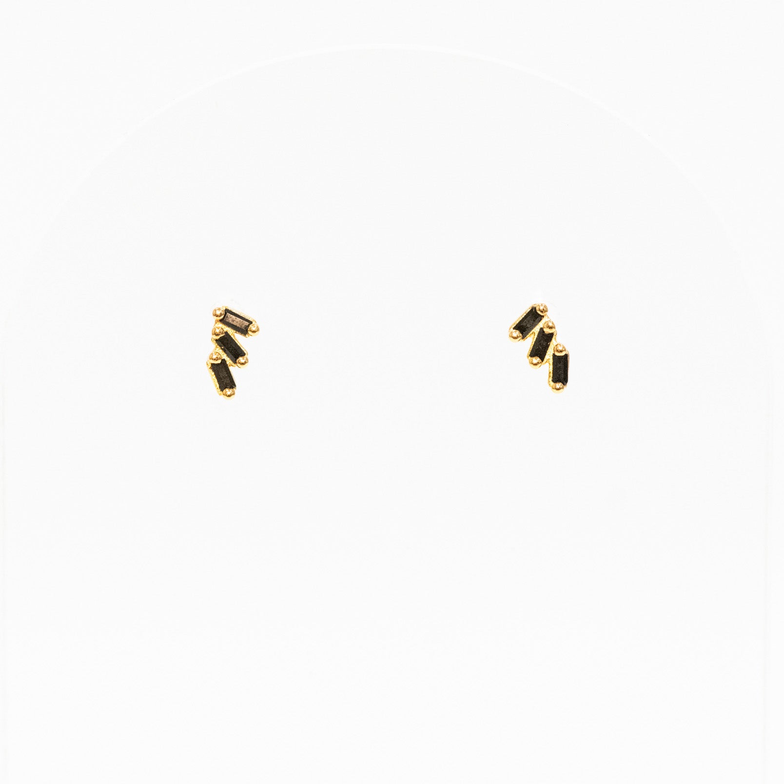 Gold earrings with black stones on a white background