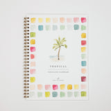 A spiral-bound watercolor workbook titled 'TROPICAL watercolor workbook' by Smile of a Studio, featuring a central palm tree illustration surrounded by a border of pastel watercolor swatches on a white cover.