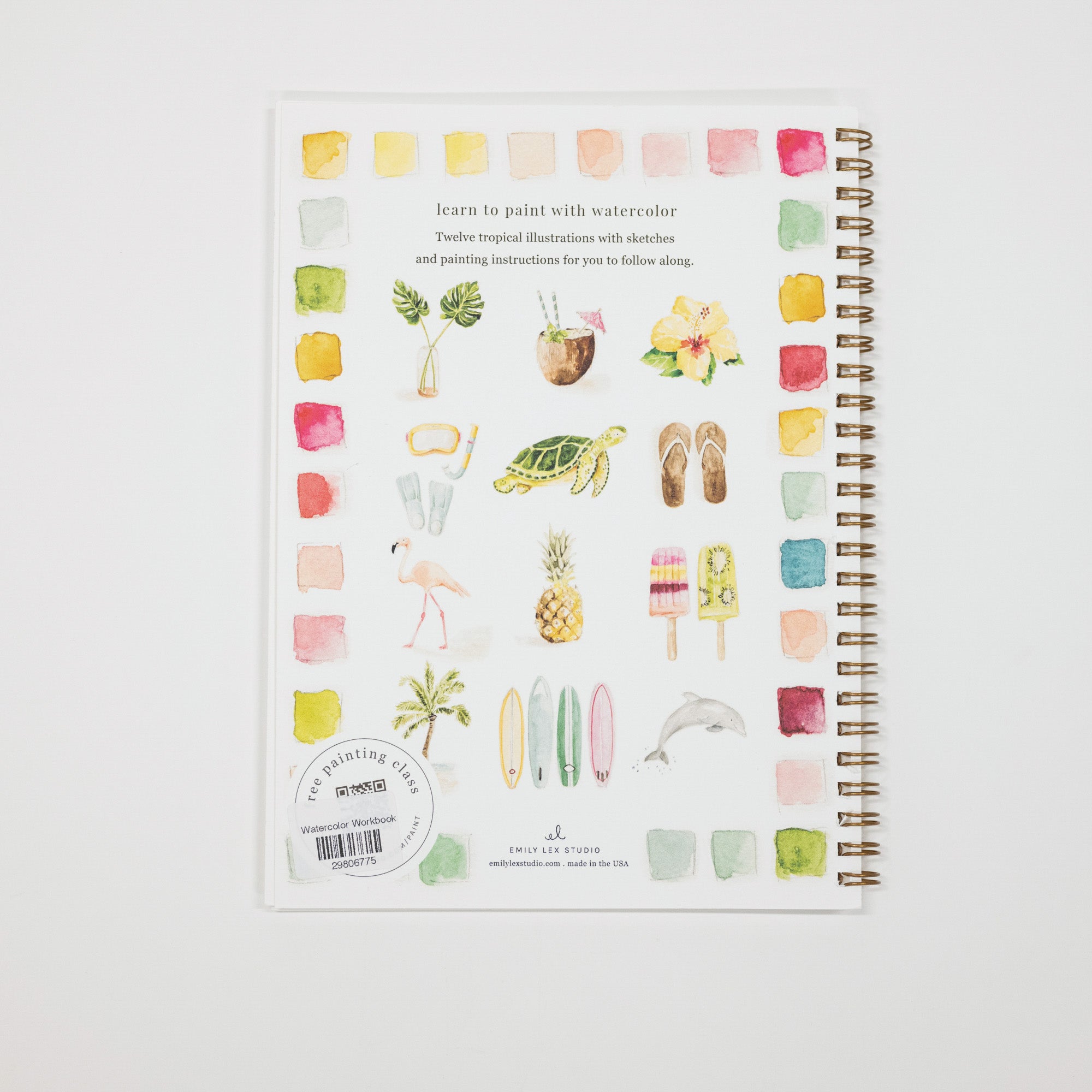 A spiral-bound watercolor painting guide book by Amy Lee Studio, featuring tropical illustrations such as a turtle, pineapple, flamingo, and surfboards on a white cover, photographed on a light gray background.