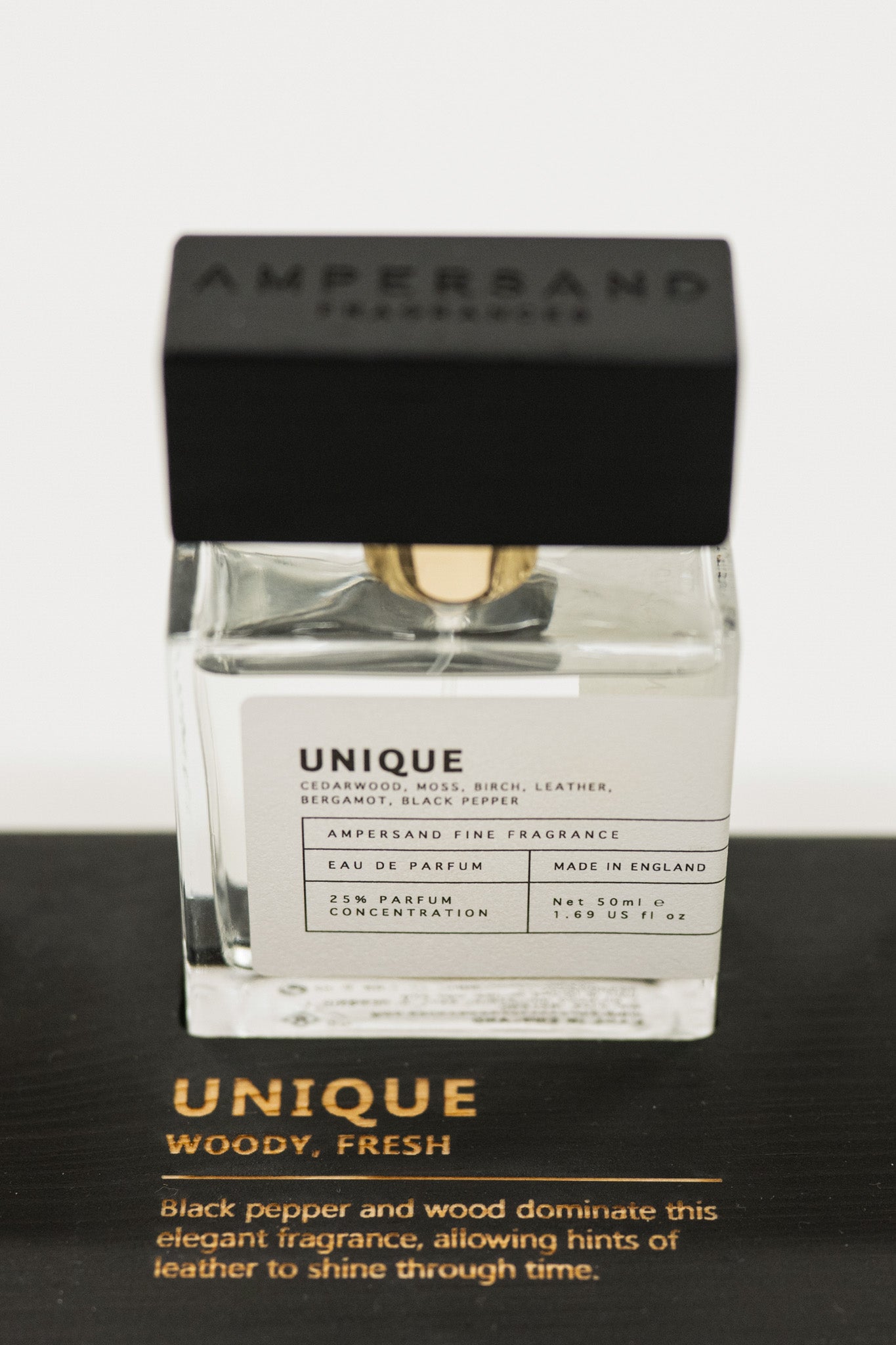 Unique Ampersand perfume bottle with black cap on a white background