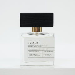 Perfume bottle labeled 'UNIQUE' on a white background