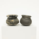 Two small black ceramic pots on a white background