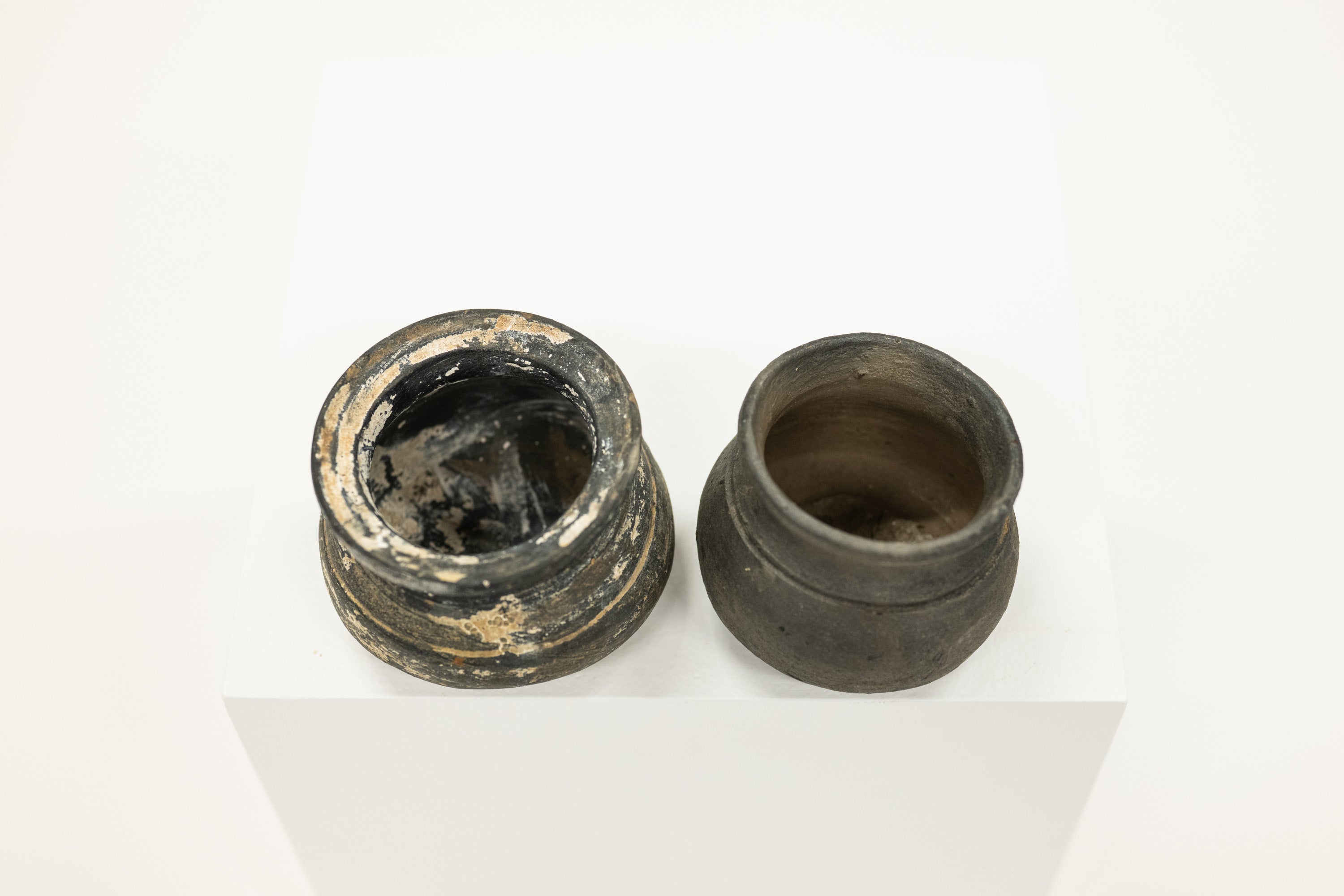 Two ancient clay pots on a white background