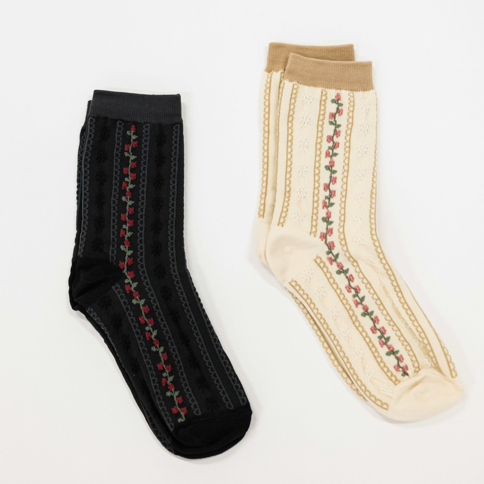 Cream and black colored crew socks featuring scalloped stripes and a stripe of flowers.