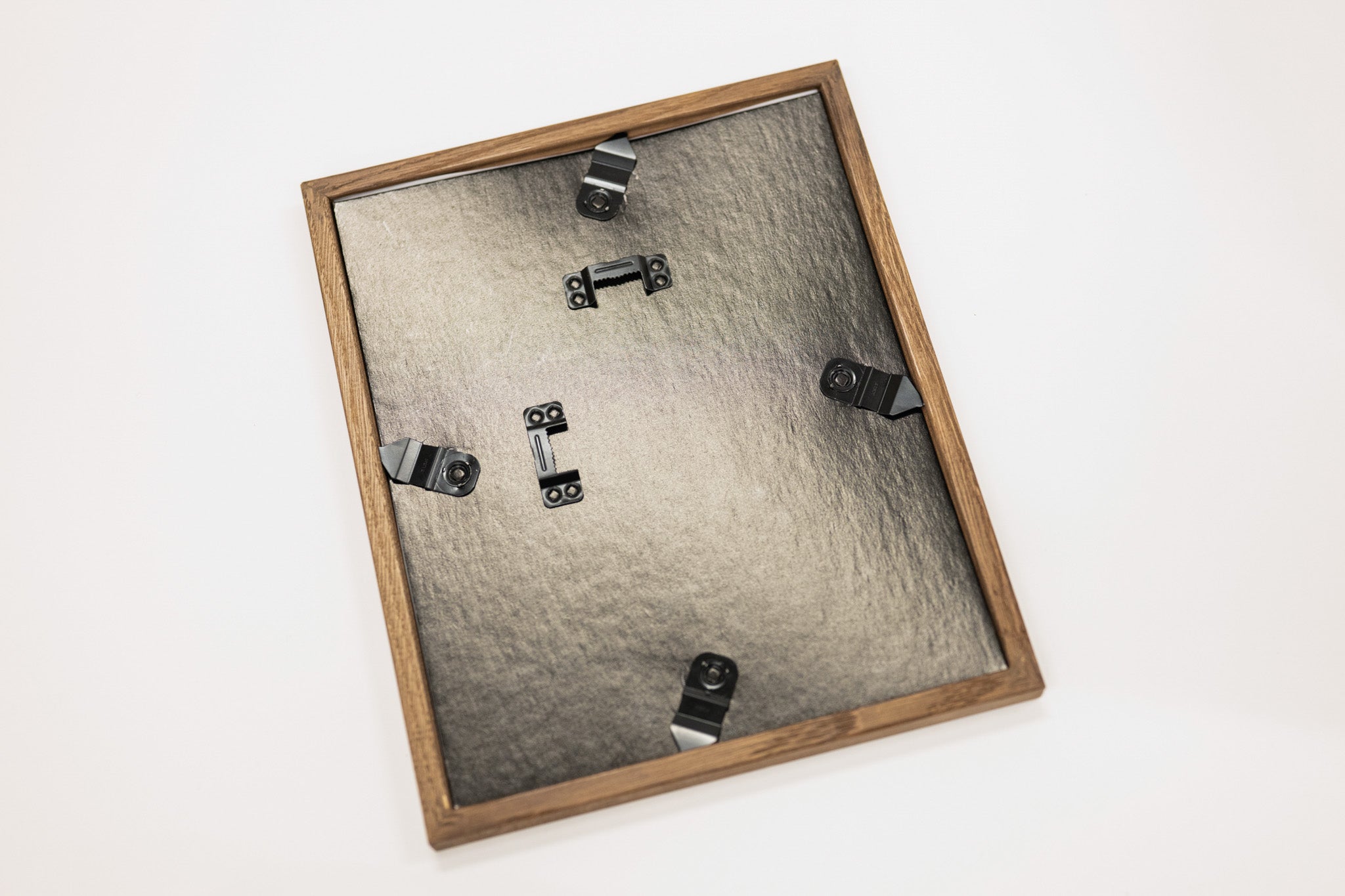 Wooden picture frame with metal hardware on a white background