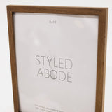 Wooden picture frame with 'Styled Abode' branding on a white background