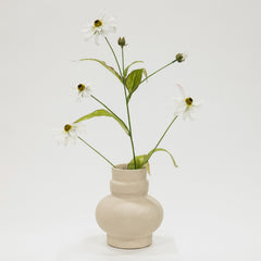 Beige ceramic vase with white flowers on a light gray background