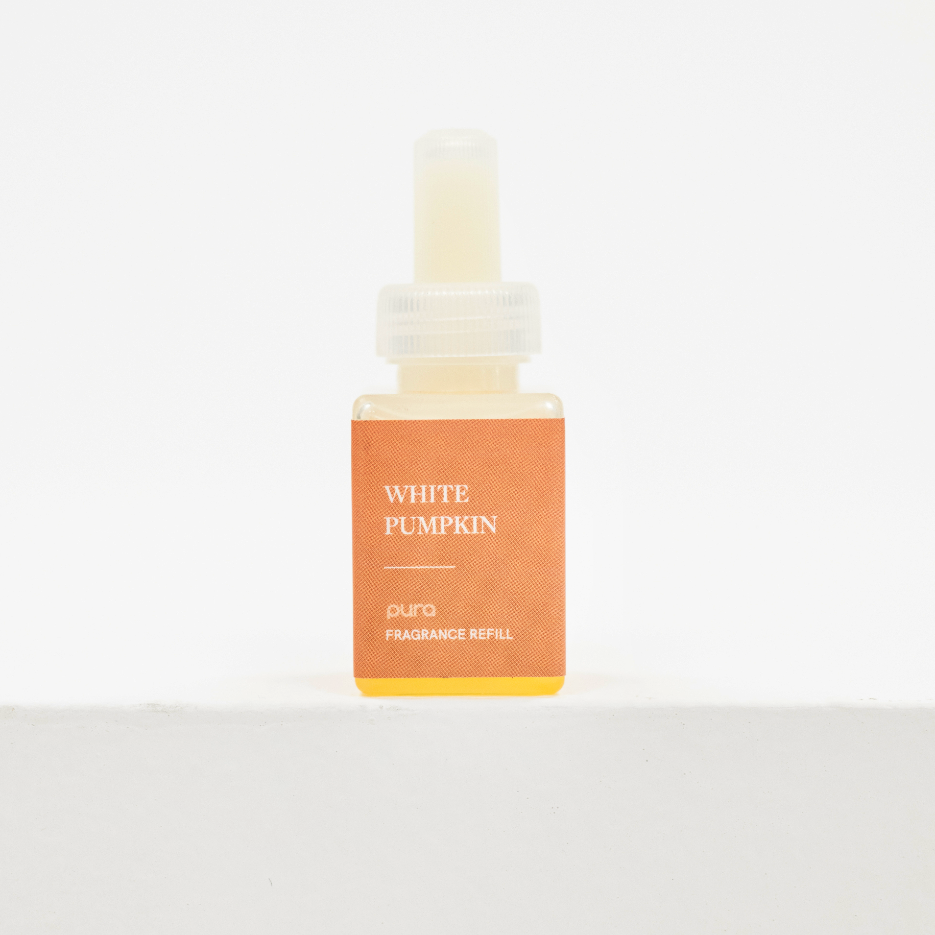 A small fragrance refill bottle labeled 'WHITE PUMPKIN' and 'puro FRAGRANCE REFILL' with an orange label and yellow base, centered on a clean white background. Fall Scents for pura.