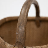 Close-up of a wicker basket with a handle on a white background