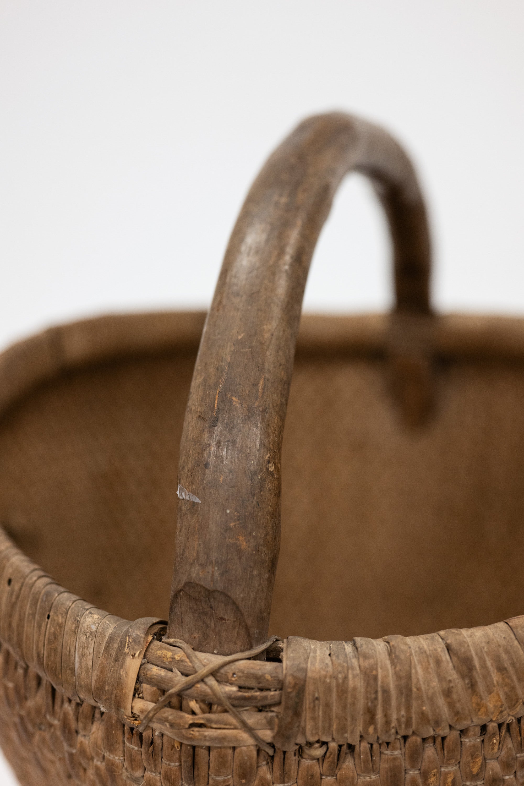 Close-up of a wicker basket with a handle on a white background