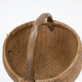 Brown woven basket with a handle on a white background