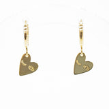 A pair of gold leverback earrings with small heart-shaped charms engraved with crescent moons and stars, displayed on a clean white background.