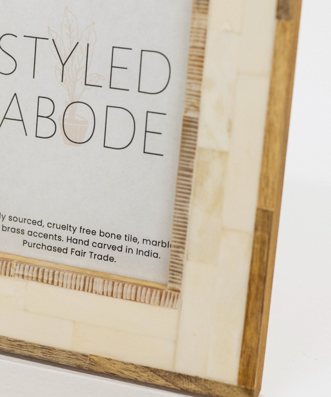 Wood and cream tile frame with 'STYLED ABODE' text on a white background