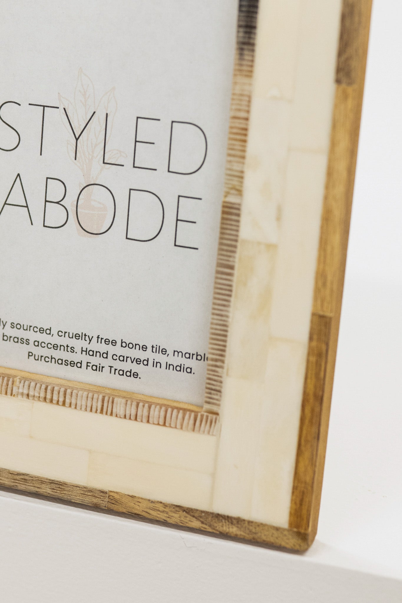 Wood and cream tile frame with 'STYLED ABODE' text on a white background