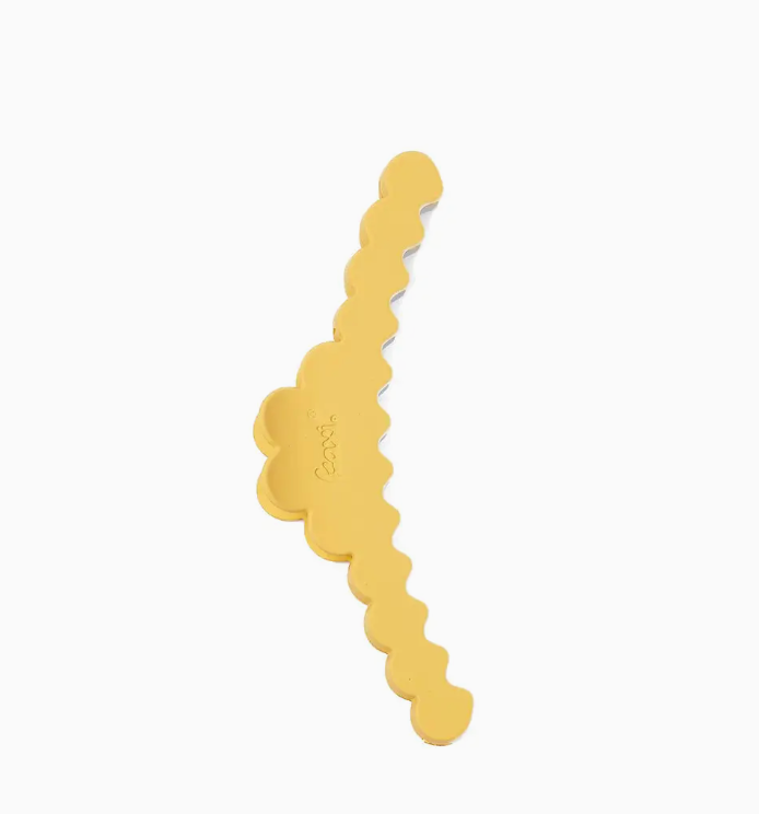 A gold-colored hair claw clip with a wavy, scalloped edge design, shown on a plain white background.